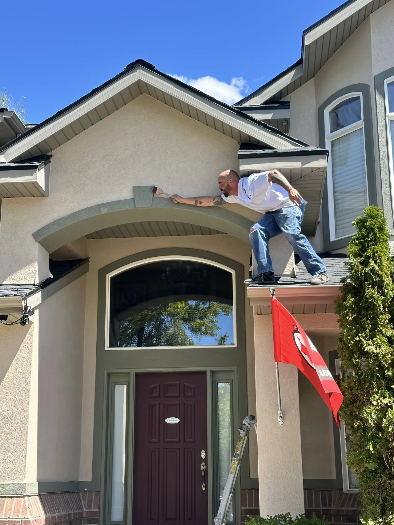 Painter hand-painting the arched entryway trim on a home in Sandy, UT