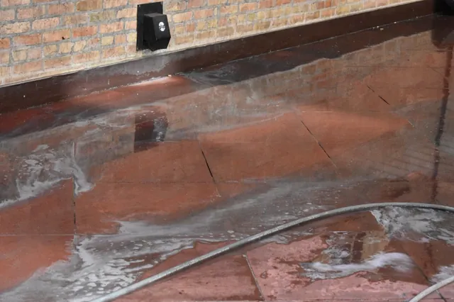 Flagstone surface half washed, showing the contrast between clean and dirty stone