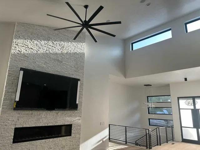 Great room with high painted ceilings and stacked-stone fireplace wall