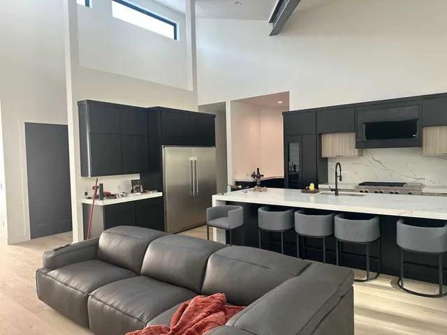 Open-concept living room and kitchen with freshly painted white walls