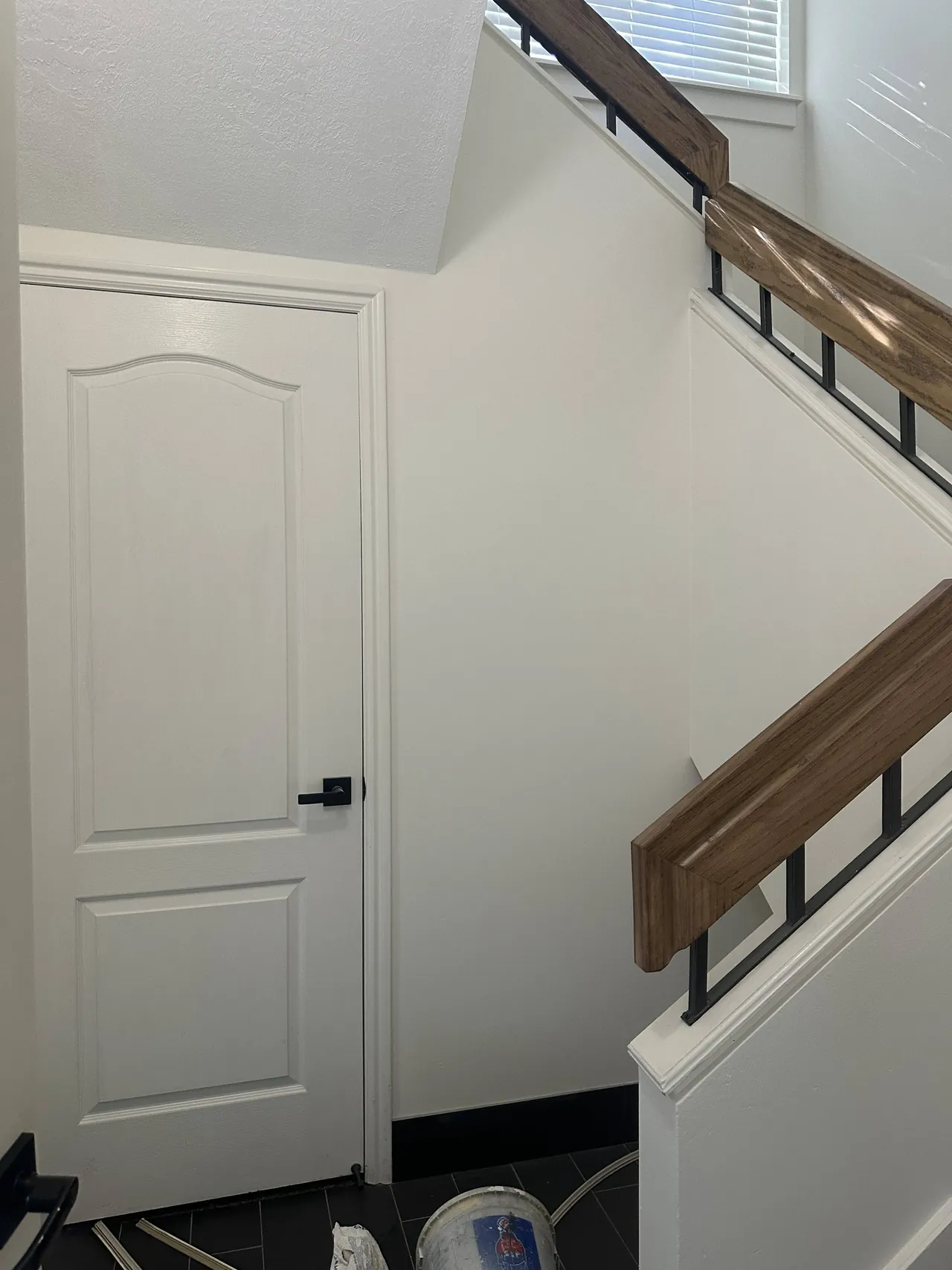 Freshly painted stairwell with white walls and wood railing