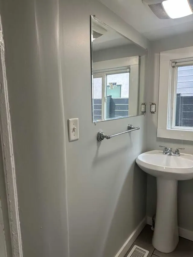 Small bathroom repainted in soft gray with pedestal sink