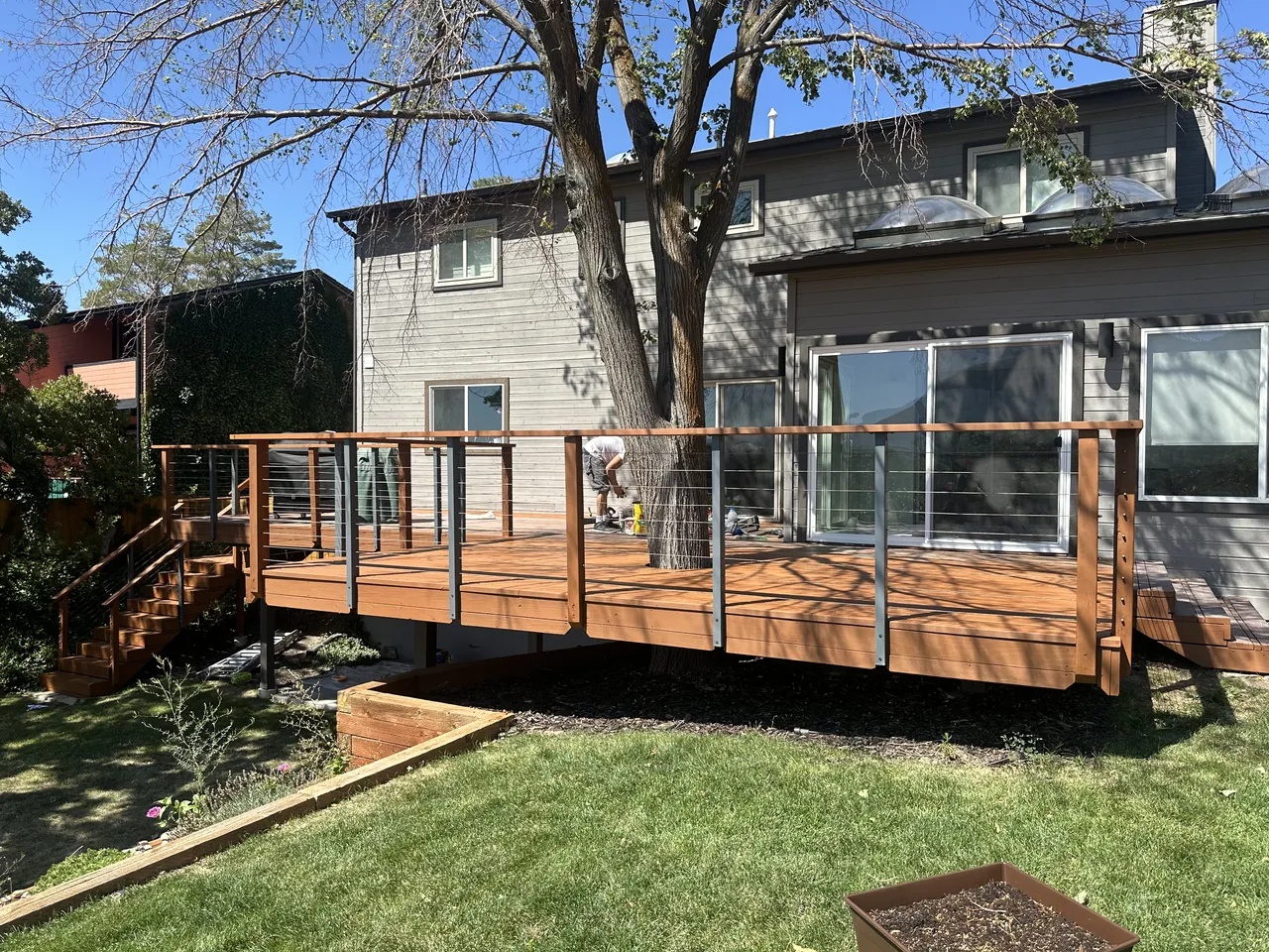 Freshly stained backyard deck with cable railing